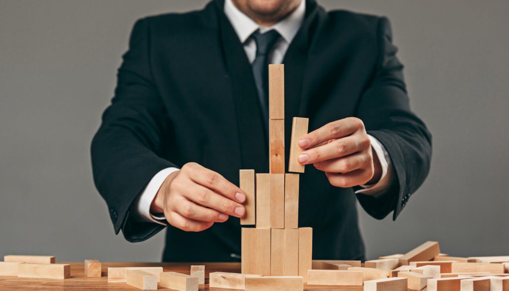 Man and wooden cubes on table. Management concept
